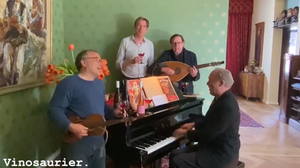 Auf dem Bild ist eine Gruppe Männer zu sehen. Einer von ihnen sitzt am Klavier. Eine weiterer spielt Gitarre. Sie trinken Vinosaurier Rosé und musizieren.