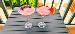 Auf dem Bild sind zwei Cocktail-Schalen zu sehen, die mit Frosé gefühlt sind. Einer ist mit Brombeeren garniert, der andere mit einer viertel Scheibe einer Wassermelone.