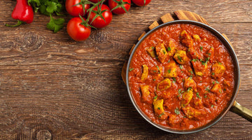 Indisches Vindaloo Curry in der Pfanne auf einem Tisch.