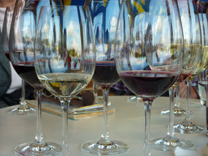 Viele Gläser Rotwein und Weißwein auf einem Tisch.