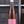 Laden Sie das Bild in den Galerie-Viewer, Eine Flasche Vinosaurier rosé vor einem Regal fotografiert. Die Flasche ist durchsichtig, sodass der Roséwein direkt zu sehen ist. Das Etikett ist rosa mit weißer Schrift. Auch der Verschluss ist weiß.
